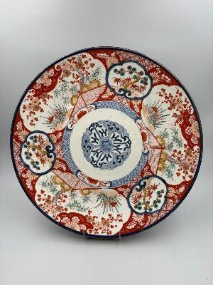 a red and blue plate with a floral design on it