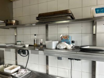 une cuisine équipée d'étagères en acier inoxydable et d'un évier