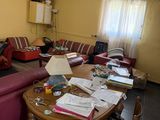 a living room with a lot of clutter and boxes on the table