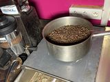 a metal pan filled with coffee beans on top of a stove