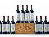 six bottles of red wine in a wooden crate on a white surface