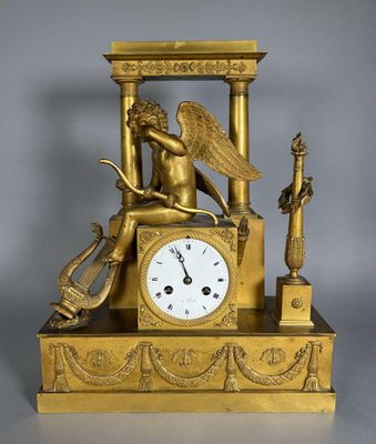 une horloge en or surmontée d'un ange