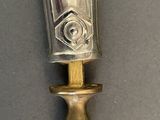 a silver spoon with a gold handle on a gray surface
