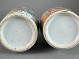pair of chinese porcelain vases with multicolored designs on them