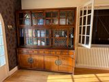 a wooden china cabinet in the corner of a room