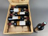 bottles of wine in a wooden box on a gray surface