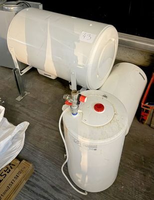 a white water tank sitting next to a white trash can