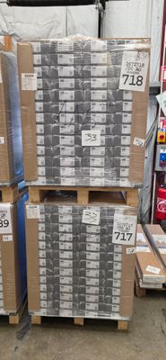 Des cartons de sodas sont empilés sur des palettes dans un entrepôt