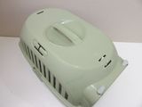 a green plastic cat carrier sitting on a white table