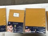 trois sacs de papier doré posés sur une table blanche