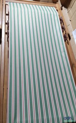 un lit rayé vert et blanc dans une petite chambre