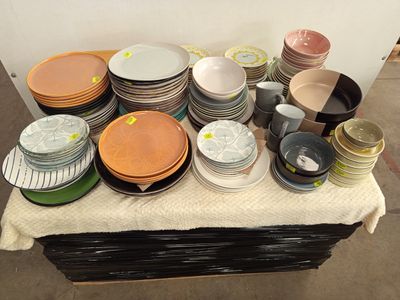 de nombreuses assiettes et bols sur une table recouverte d'une nappe blanche