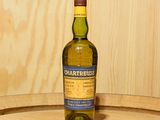 une bouteille de whisky posée sur un tonneau en bois