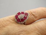 la main d'une femme tenant une bague sertie d'un diamant et d'un rubis