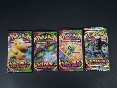 trois paquets de cartes à collectionner Pokémon posés sur une table