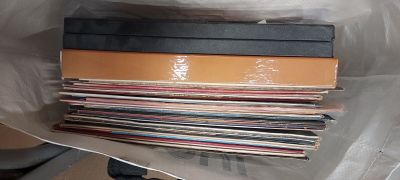 plein de disques dans un sac en plastique posé par terre