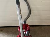 a vacuum that is sitting on the floor in front of a garage door