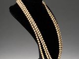 a necklace with pearls on a mannequin stand