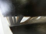un gros plan sur une tache de peinture noire sur un morceau de bois