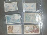 six billets de banque différents se trouvent dans un sac en plastique posé sur une table