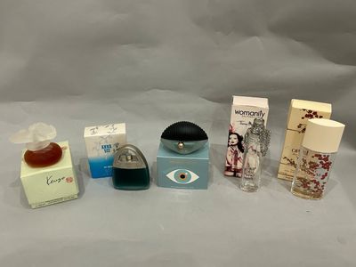 Plusieurs parfums différents sont alignés sur une surface blanche