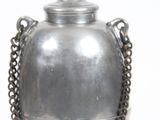 un vase en argent entouré d'une chaîne, sur fond blanc