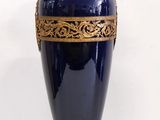 a blue vase with a gold decoration on it