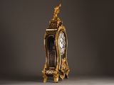 a gold clock with a bird on top of it