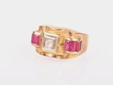 gros plan d'une bague en or avec des pierres roses et blanches