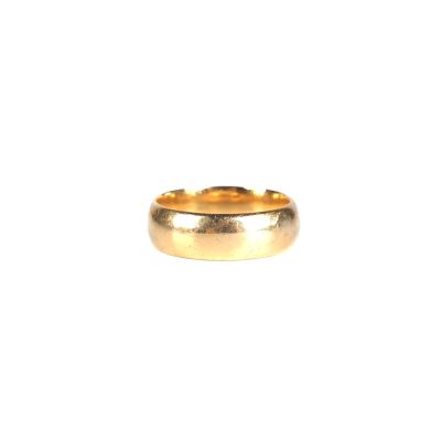 gros plan d'une bague en or sur fond blanc