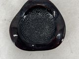a small black object on a white surface that looks like a heart