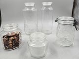 four glass jars with nuts in them sitting on a table