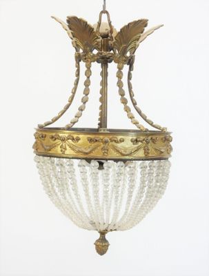 un lustre suspendu au plafond, sur lequel est perché un oiseau