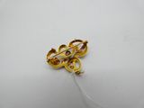 an image of a gold brooch with a diamond in the center