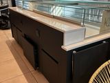 un comptoir avec une vitrine et une chaise devant