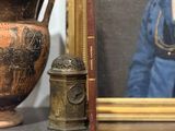 une photo d'une femme en robe bleue, à côté d'un vase et d'un livre