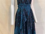 Le mannequin porte une robe bleue à motifs floraux.