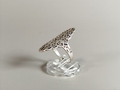 sterling silver ring with filigree filigree design on a clear acrylic base