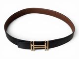 a close up of a black belt with a gold buckle