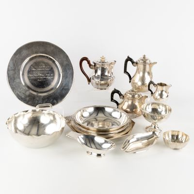 un plateau en argent et des couverts en argent posés sur une table blanche