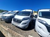 de nombreuses camionnettes blanches garées en file sur le bord de la route