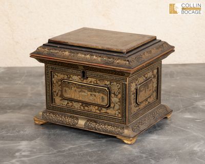 une petite boîte en bois avec un couvercle en métal, posée sur une table