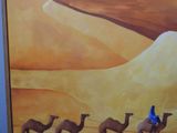 a painting of a man riding a camel with a group of camels