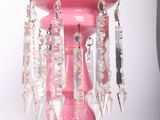 a pink vase that has a bunch of beads hanging from it