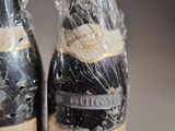 two bottles of wine wrapped in plastic on a table