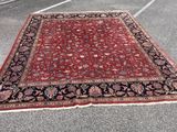 a red and black rug sitting on top of a parking lot