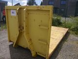 a yellow dumpster sitting on the ground in front of a building