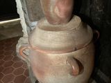 a large clay pot with a lid sitting on top of it