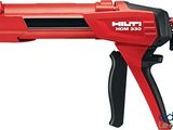 un gros plan d'un pistolet à colle rouge brûlant sur fond blanc