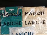 two shirts and a bag of clothes sitting on a table